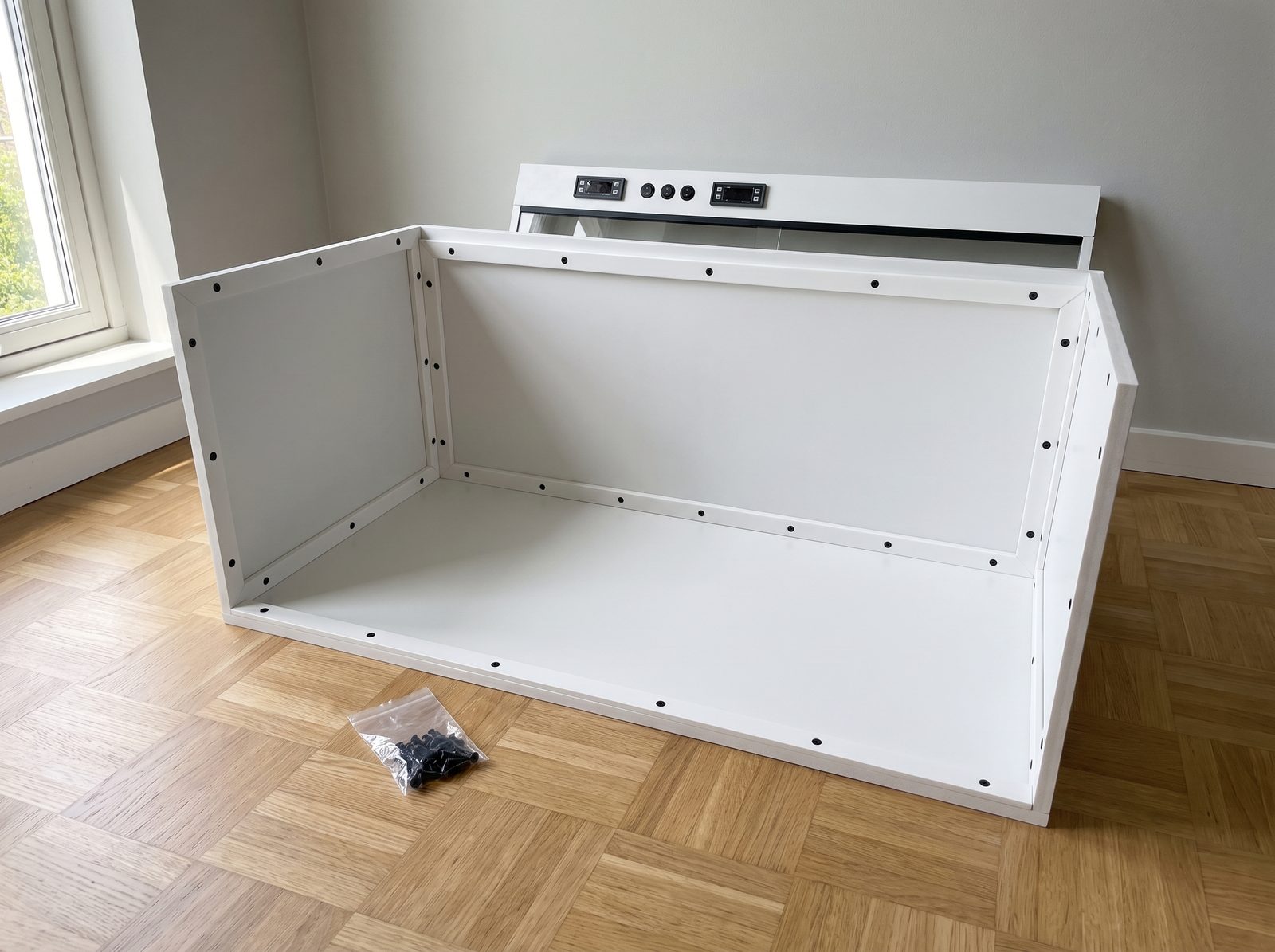 Le fond et les deux cotes du terrarium assembles, formant un caisson ouvert sur l'avant